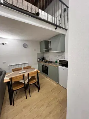 a kitchen and dining room with a table and chairs at Kiccifù home in Palermo