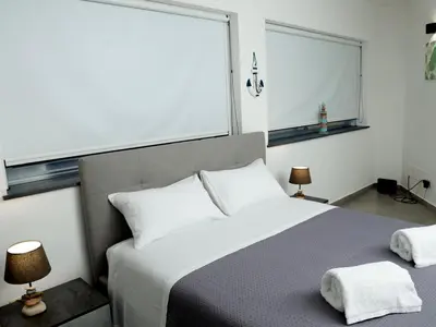 a kitchen with a table and a black couch and a kitchen at Anciovi Rooms in Bagheria