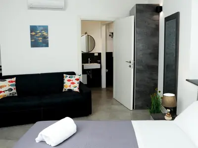 a bedroom with a bed and a window and a lamp at Anciovi Rooms in Bagheria