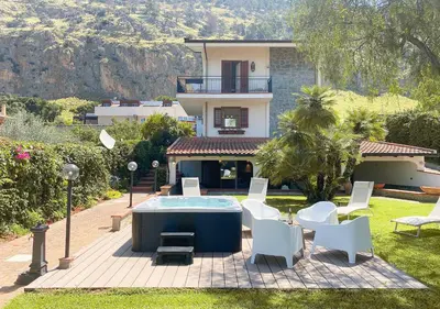 a patio with chairs and a pool in front of a house at Solemar Sicilia - Villa Alma in Palermo