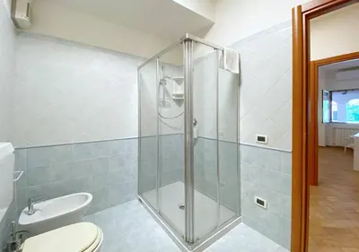 a bathroom with a toilet and a glass shower at Solemar Sicilia - Villa Alma in Palermo