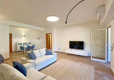a living room with a white couch and a tv at Solemar Sicilia - Villa Alma in Palermo