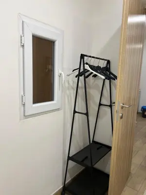 a black shelf in a room next to a door at Oasi house in Palermo