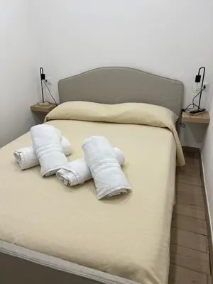 a bed with two towels and two pillows on it at Oasi house in Palermo