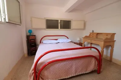 a small bedroom with a bed and a desk at Villa Barbera - Terrace overlooking the sea in Bagheria