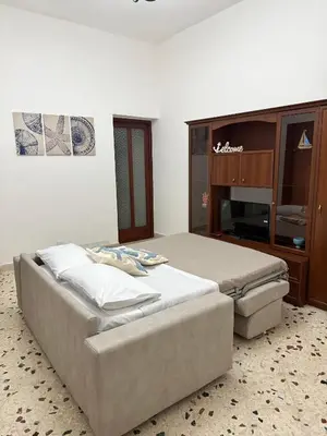 a bedroom with two beds and a tv at Dimora Anastasia - Alloggio nel cuore di Balestrate in Balestrate
