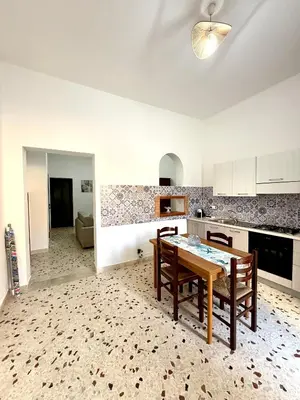 a kitchen with a table and chairs in a room at Dimora Anastasia - Alloggio nel cuore di Balestrate in Balestrate