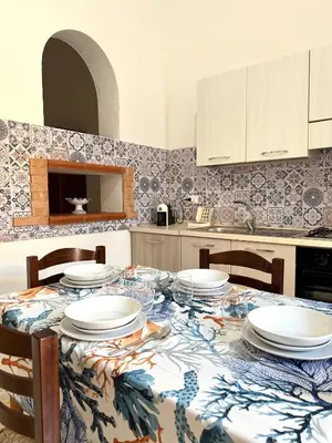 a kitchen with a table with plates on it at Dimora Anastasia - Alloggio nel cuore di Balestrate in Balestrate