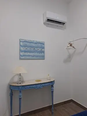 a blue table with a lamp on a wall at PHI-Lampara in Santa Flavia
