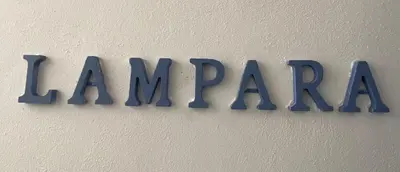 a sign that readsarma hanging on a wall at PHI-Lampara in Santa Flavia