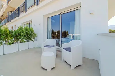 a balcony with white chairs and a table at Hybrid Icon Rooms Gallery in Palermo