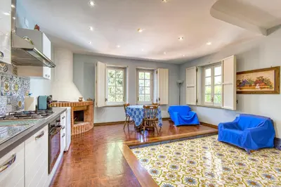a kitchen with blue chairs and a table at VFH Villa Cala del Cuore con piscina, 50 m dal mare in Santa Flavia