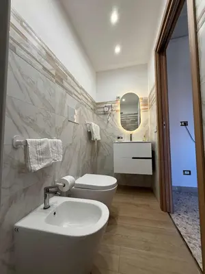 a white bathroom with a sink and a toilet at nuova oreto stazione rooms in Palermo