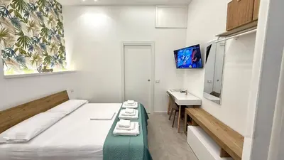 a room with a bed and a sink and a television at Damasa House in Balestrate
