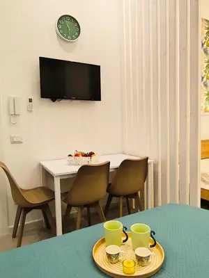a dining room with a table with chairs and a clock at Damasa House in Balestrate
