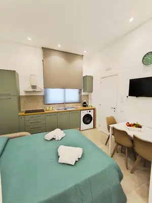 a kitchen with a green table with two towels on it at Damasa House in Balestrate