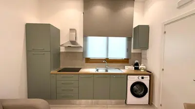a kitchen with green cabinets and a washing machine at Damasa House in Balestrate