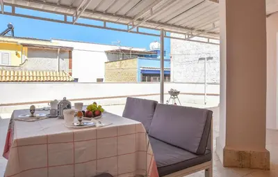 a table with a plate of fruit on top of a balcony at Amazing Apartment In Trappeto With Wifi in Trappeto