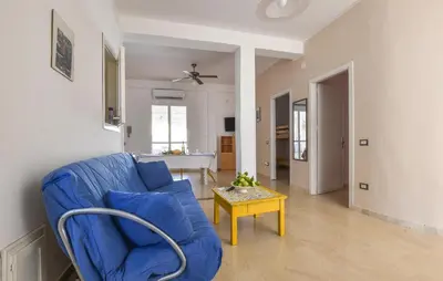 a living room with a blue couch and a table at Amazing Apartment In Trappeto With Wifi in Trappeto