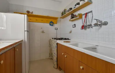 a kitchen with a sink and a white tiled wall at Amazing Apartment In Trappeto With Wifi in Trappeto