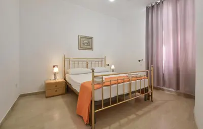 a bedroom with a bed with an orange blanket on it at Amazing Apartment In Trappeto With Wifi in Trappeto