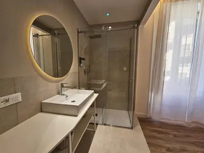 a bathroom with a sink and a shower with a mirror at Dolce Dormire in Palermo