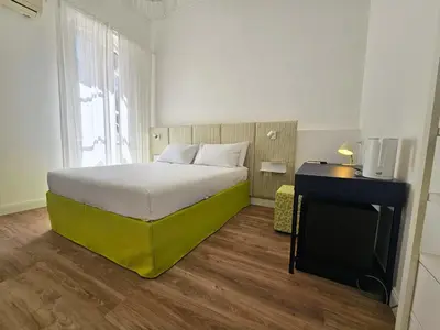 a hotel room with a bed and a desk at Dolce Dormire in Palermo