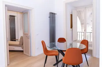 a dining room with a glass table and orange chairs at 4Quarti in Palermo