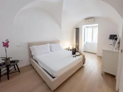 a white bedroom with a large bed and a window at 4Quarti in Palermo
