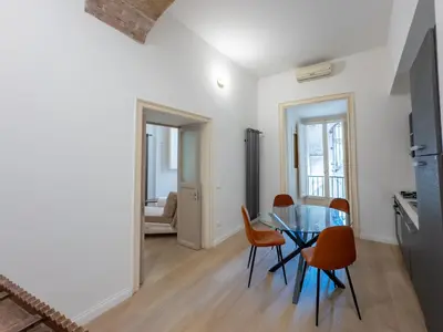 a kitchen and dining room with a glass table and chairs at 4Quarti in Palermo