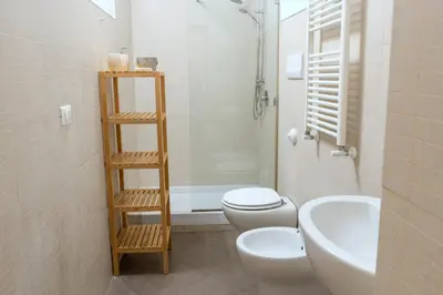 a bathroom with a white toilet and a sink at 4Quarti in Palermo