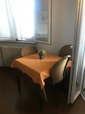 a table with chairs and a vase of flowers on it at b&b Simpaty in Mondello