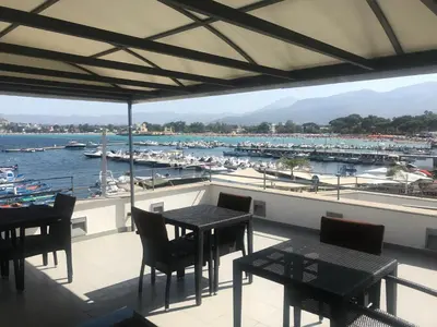 a balcony with tables and chairs and a marina at b&b Simpaty in Mondello