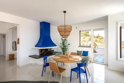a dining room with a table and blue chairs at Sea Frame Design Apartments with Pool by Wonderful Italy in Santa Flavia