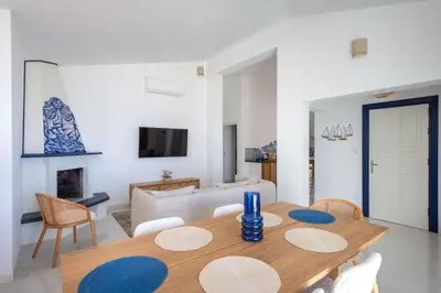 a living room with a wooden table and chairs at Sea Frame Design Apartments with Pool by Wonderful Italy in Santa Flavia