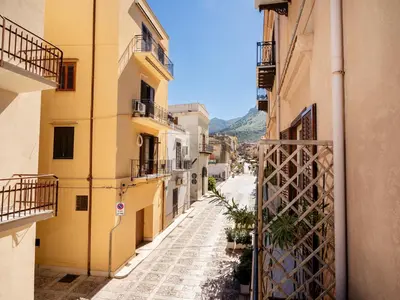 an alley in an old town with yellow buildings at Dimora Puccini by Holiday World in Castellammare del Golfo