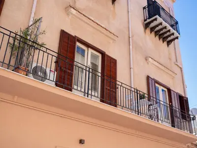 a building with balconies and windows with plants on it at Dimora Puccini by Holiday World in Castellammare del Golfo