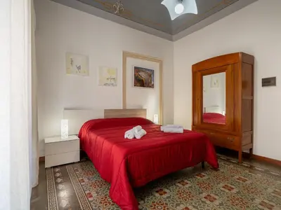 a bedroom with a red bed with two stuffed animals on it at Dimora Puccini by Holiday World in Castellammare del Golfo