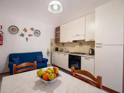 a kitchen with a table with a bowl of fruit on it at Dimora Puccini by Holiday World in Castellammare del Golfo
