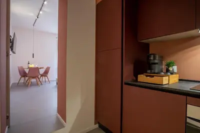 a kitchen with a counter and a table with chairs at Corallo - Cantunera Old Town Apartments in Palermo