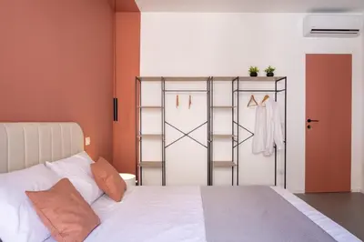 a bedroom with a bed and a clothes rack at Corallo - Cantunera Old Town Apartments in Palermo