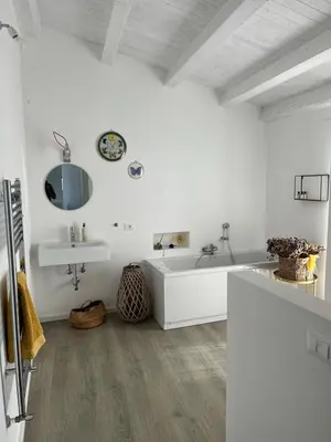 a white bathroom with a tub and a sink at Casa Mulinazzo in Cinisi