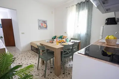 a kitchen and dining room with a wooden table and chairs at inHouse Palermo in Palermo