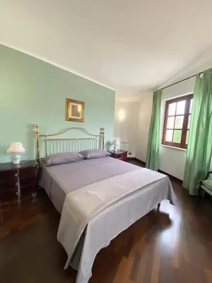 a bedroom with a large bed with green curtains at Casa Mini' in Palermo