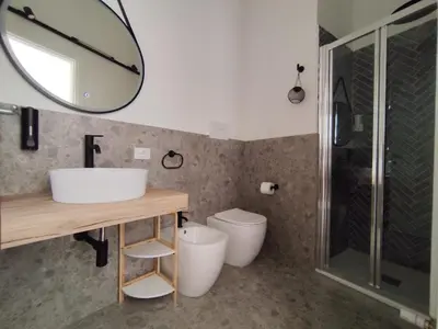 a bathroom with a sink and a mirror and a toilet at Cà Mami Rooms in Palermo