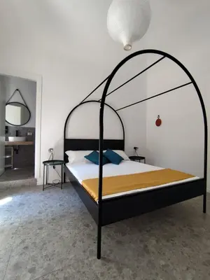 an iron canopy bed in a bedroom with at Cà Mami Rooms in Palermo