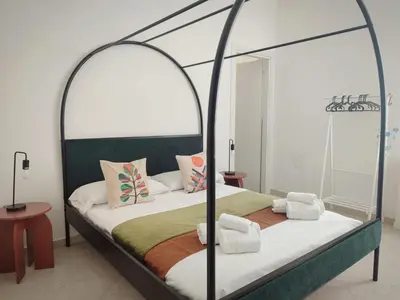 a bedroom with a bed with an iron canopy at Cà Mami Rooms in Palermo