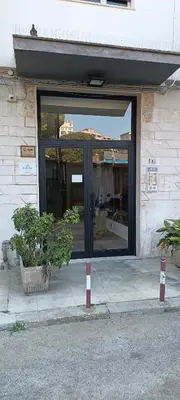 a glass door of a building with a potted plant at Airoldi Home in Palermo