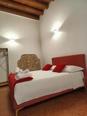 a bedroom with a large white bed with red pillows at Bellini al Massimo in Palermo