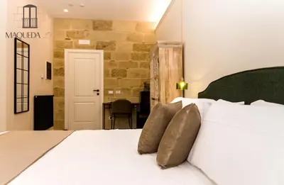 a bedroom with a white bed with two pillows at Maqueda 259 - In Palermo's Lively Heart in Palermo